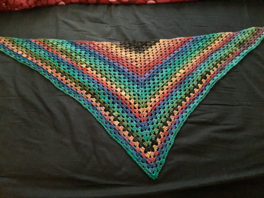 Photo of a crocheted shawl with rainbow stripes